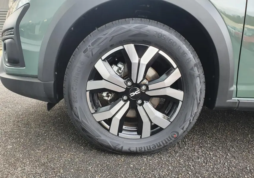 Gros plan sur la roue avant droite du Dacia Jogger 2024 en Licken Kaki avec jante alliage bicolore.