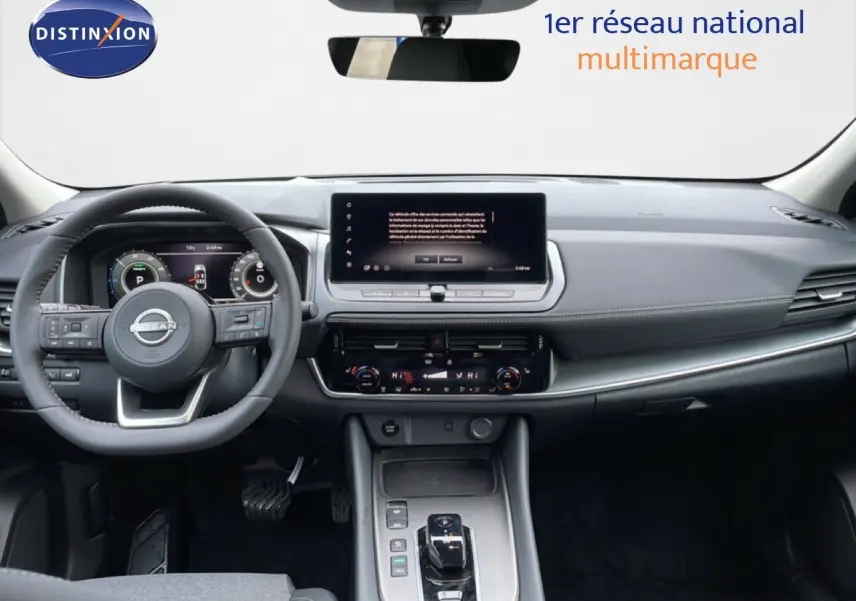 Intérieur du Nissan Qashqai 2025 gris, vue frontale sur le tableau de bord moderne avec écran tactile et volant multifonction.