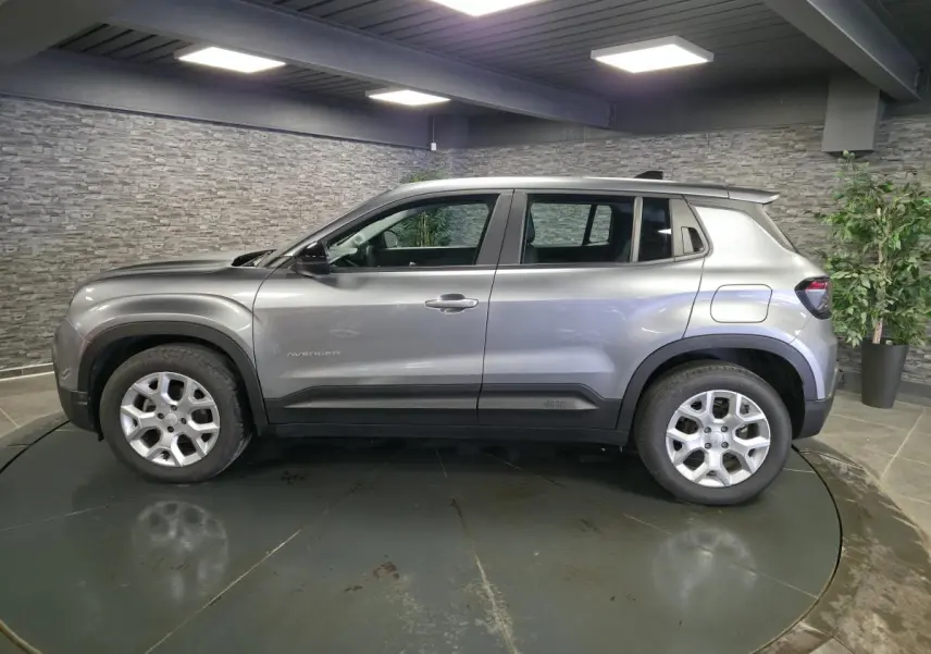 Vue de profil côté gauche du Jeep Avenger gris métallisé 2025 avec jantes alliage 17 pouces et coques de rétroviseurs noires.