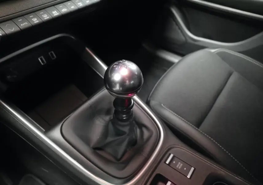 Gros plan sur la boîte manuelle et le siège avant droit noir du Jeep Avenger 2025 gris, intérieur moderne et épuré.