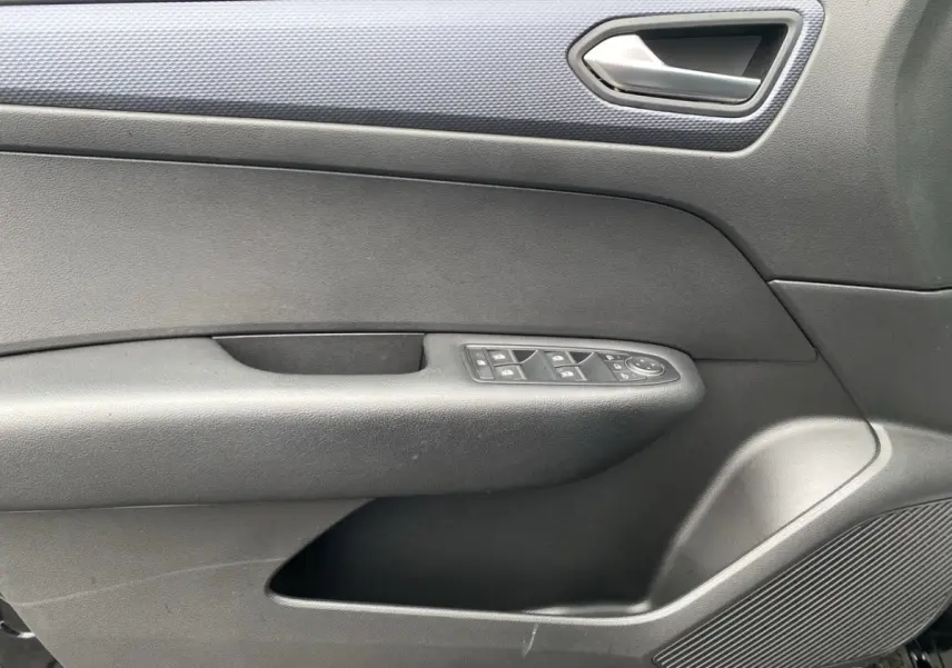 Gros plan de la porte intérieure côté conducteur noire du Renault Arkana avec commandes électriques des vitres et poignée argentée.
