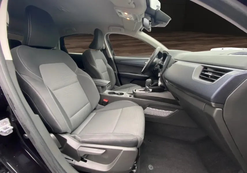 Vue intérieure côté conducteur du Renault Arkana noir 2024, sièges tissu gris avec console centrale et tableau de bord moderne.
