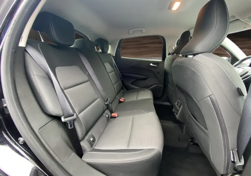 Vue intérieure arrière du Renault Arkana 2024 noir, montrant les sièges arrière en tissu et cuir avec ceinture de sécurité.
