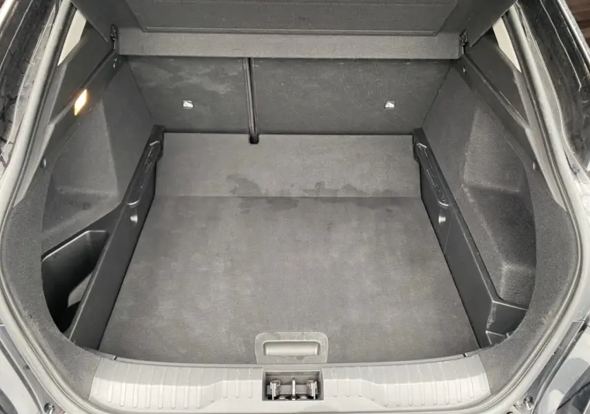 Coffre ouvert du Renault Arkana noir, vue plongeante montrant l'espace de chargement vide et les finitions intérieures.
