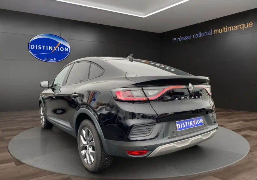 Vue 3/4 arrière droite d'un Renault Arkana noir 2024 avec feux LED et logo ARKANA lumineux sur coffre.