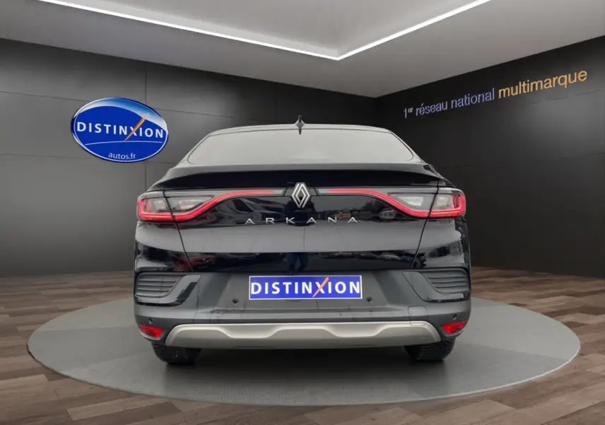 Vue arrière d'un Renault Arkana noir 2024 avec feux LED reliés et logo central sur fond showroom.