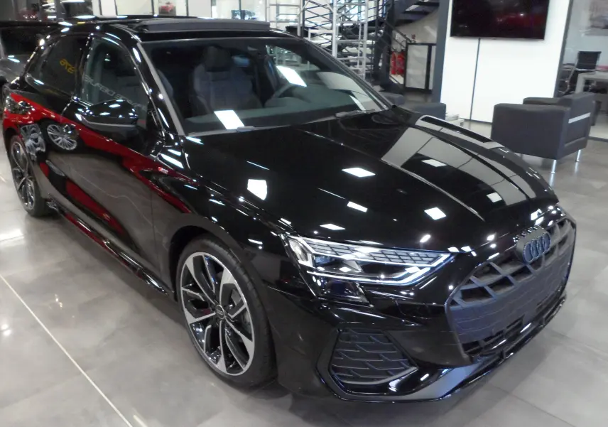 Audi A3 Sportback 35 TFSI noir Mythe vue 3/4 avant droit en showroom avec jantes biton et phares LED.