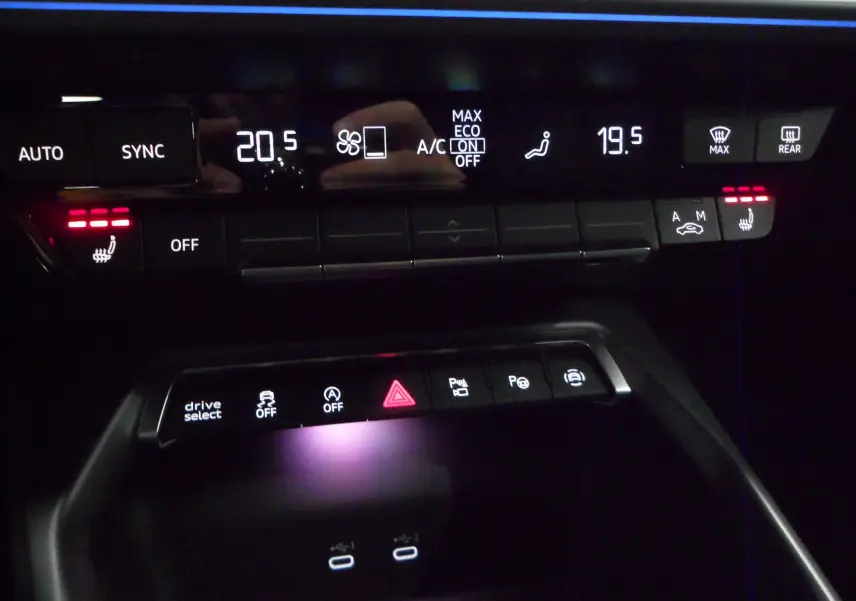 Détail du tableau de bord de l'Audi A3 Sportback 2025 montrant les commandes de climatisation et les boutons d'assistance éclairés.