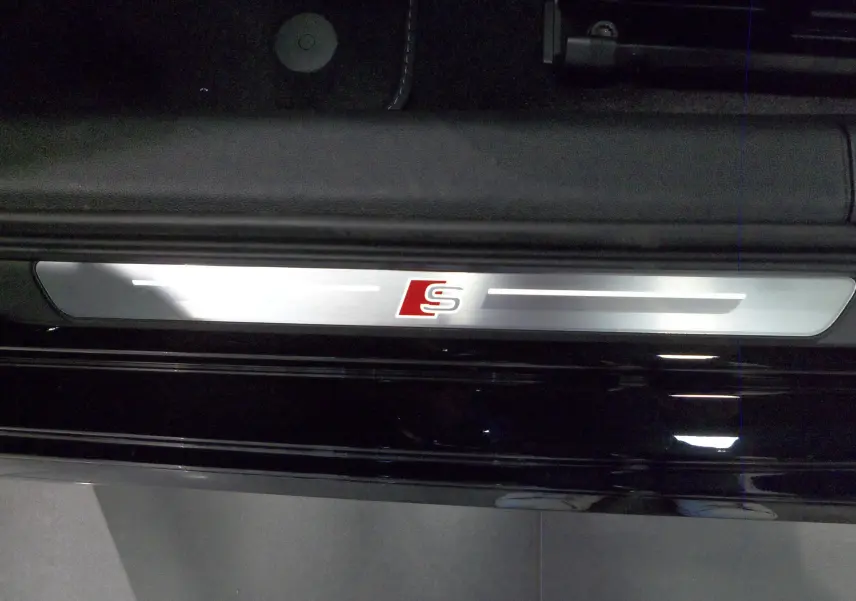 Seuil de porte intérieur avec logo S en métal brossé sur Audi A3 Sportback Noir Mythe, vue rapprochée côté gauche.