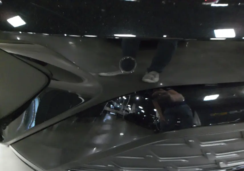 Vue rapprochée du coffre ouvert d'une Audi A3 Sportback 35 TFSI noir Mythe, reflet brillant sur la carrosserie.