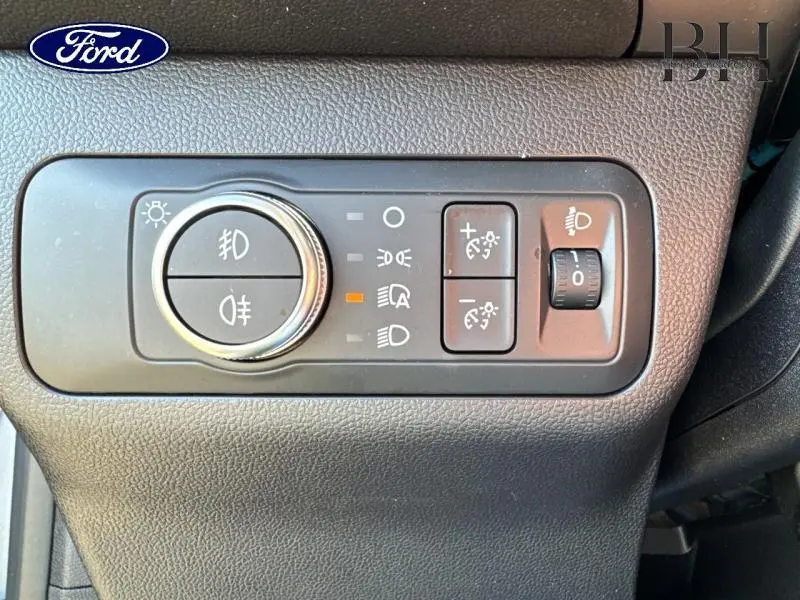 Gros plan sur les commandes d'éclairage du Ford Kuga 2023, avec réglages des phares et feux antibrouillard.