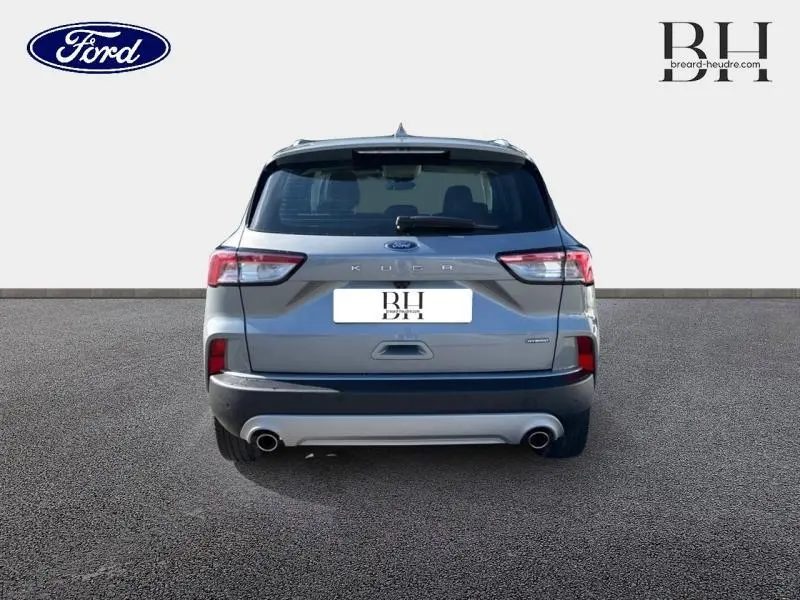 Vue arrière d'un Ford Kuga 2023 gris Solar métallisé avec double sortie d'échappement et barres de toit visibles.