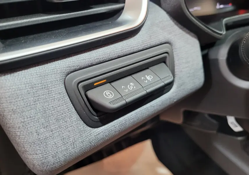 Gros plan sur les commandes d'éclairage et réglage du tableau de bord de la Renault Clio gris foncé Evolution Blue dCi 2025.