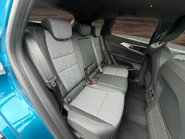 Vue intérieure arrière droite du Renault Austral bleu 2026, montrant la banquette trois places en tissu gris et cuir noir.