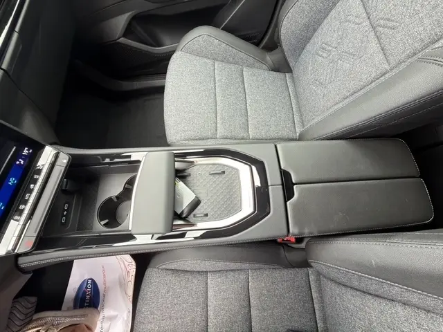 Vue intérieure rapprochée du Renault Austral 2026, montrant la console centrale noire et les sièges tissu gris clair.