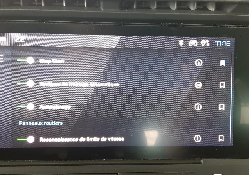 Écran tactile intérieur du tableau de bord de la Peugeot 308 blanc banquise, affichant les réglages d'aide à la conduite.