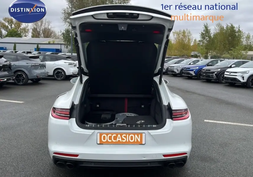 Vue arrière d'une Porsche Panamera 4 E-Hybrid blanche avec coffre ouvert montrant l'espace de chargement.