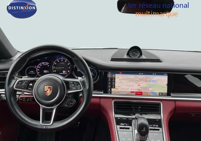 Vue intérieure du tableau de bord et volant noir du Porsche Panamera 4 E-Hybrid 2017 avec écran de navigation allumé.