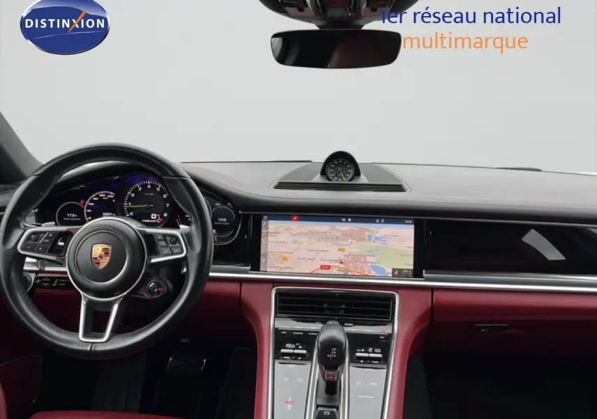 Vue intérieure du tableau de bord et volant noir d'une Porsche Panamera 4 E-Hybrid 2017 avec sellerie cuir bordeaux.