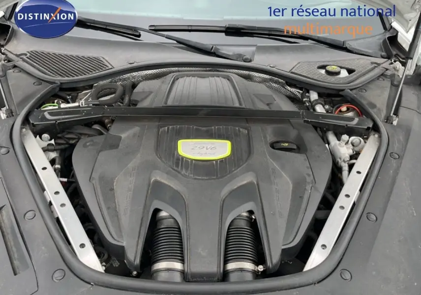 Vue rapprochée du moteur 2.9 V6 hybride de la Porsche Panamera 4 E-Hybrid blanche, capot ouvert.