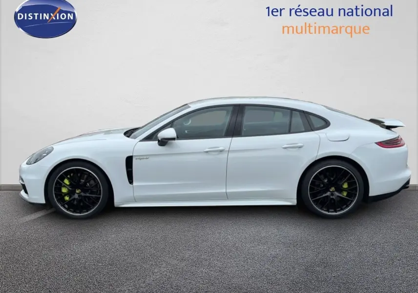 Profil côté gauche d'une Porsche Panamera 4 E-Hybrid blanche avec jantes sport noires et étriers verts.