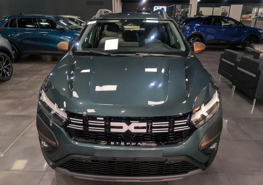 Vue frontale d'une Dacia Sandero Stepway TCe 110 en Vert Cèdre, avec calandre noire et logo Stepway visible.