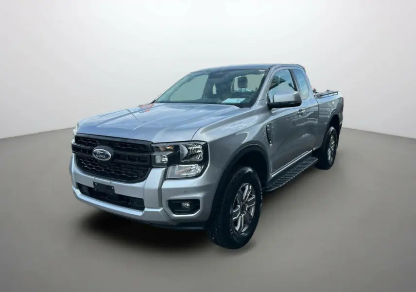 Ford Ranger gris iconic en 3/4 avant droit avec marchepieds latéraux et calandre noire distinctive.