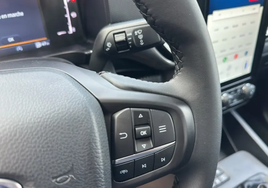 Gros plan sur le volant cuir multifonctions du Ford Ranger 2026 avec écran tactile et commandes intégrées.