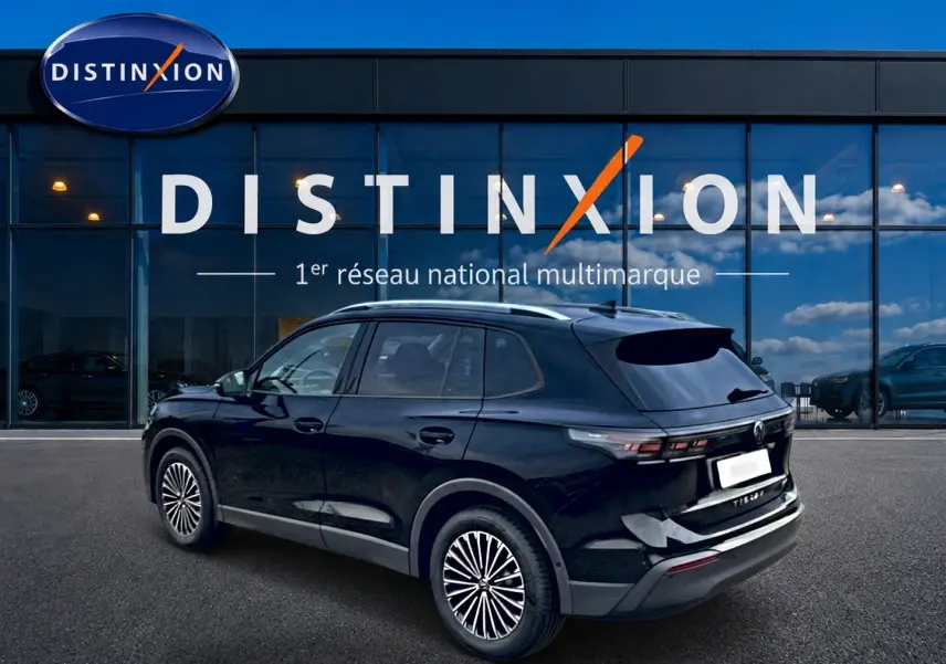 Volkswagen Tiguan noir 2025 en 3/4 arrière droit, avec barres de toit argentées et jantes stylisées.