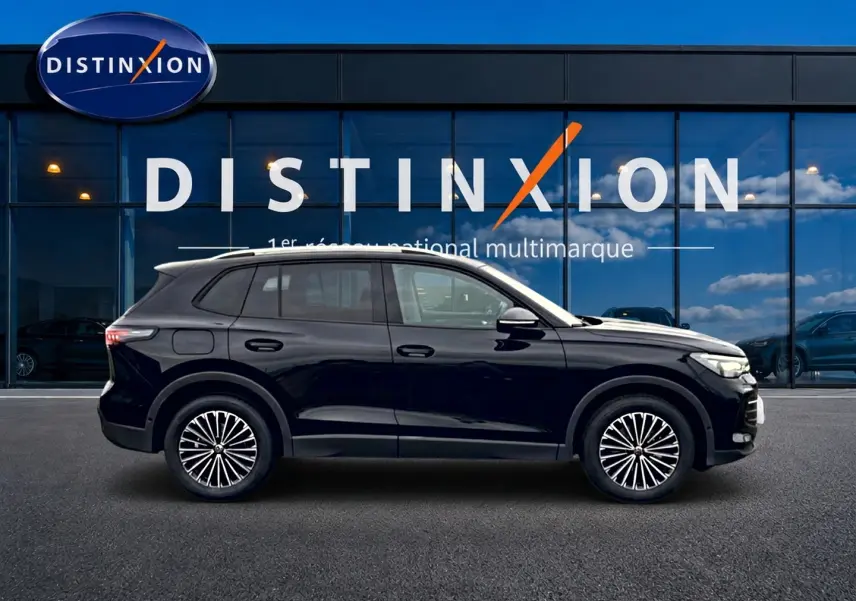 Volkswagen Tiguan 2025 noir en profil droit, avec jantes stylisées et toit ouvrant panoramique visible.