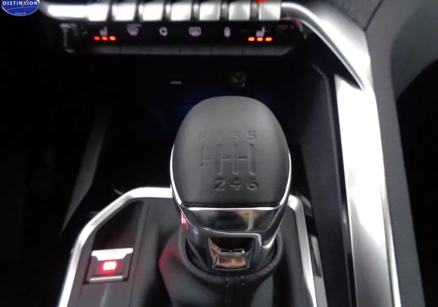 Le levier de vitesse manuel 6 rapports du Peugeot 3008 2023 en gros plan, entouré de finitions chromées.