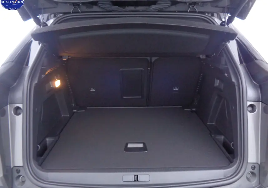 Coffre ouvert du Peugeot 3008 gris platinium métal, vue arrière montrant un espace de chargement spacieux et éclairé.