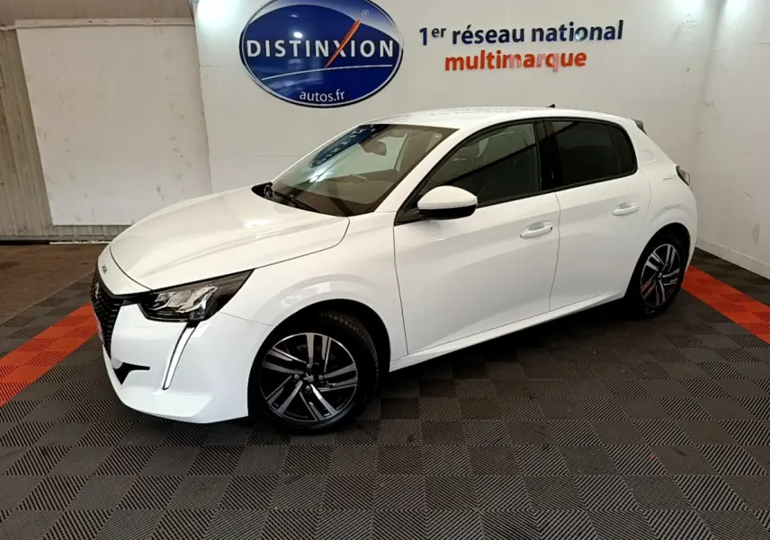 Peugeot 208 blanc vue 3/4 avant droit, avec jantes alliage et vitres teintées en intérieur showroom