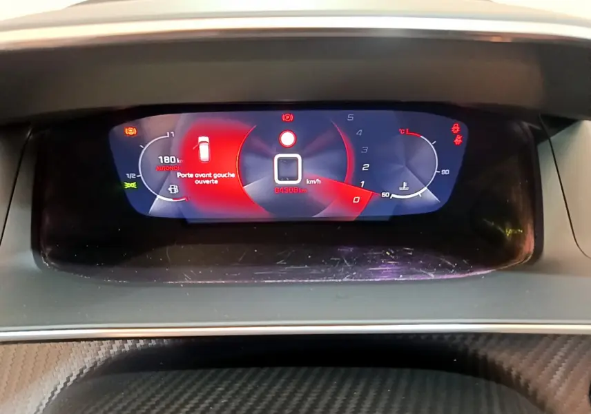 Affichage numérique du tableau de bord de la Peugeot 208 blanc, montrant une porte avant gauche ouverte et 64 309 km au compteur.