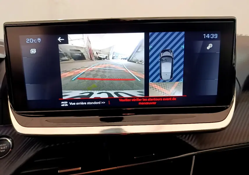 Écran tactile central montrant la caméra de recul et l'aide au stationnement du Peugeot 208 blanc, vue intérieure avant.