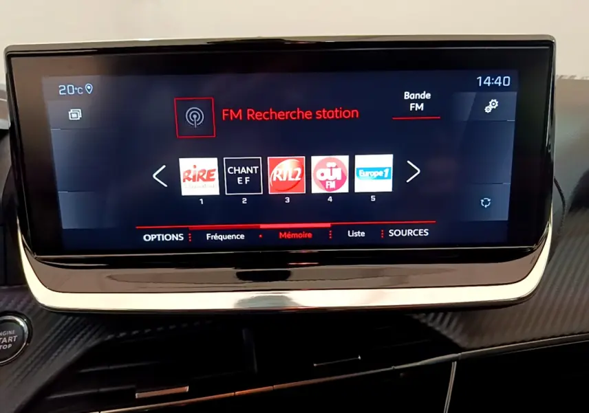 Écran tactile central du tableau de bord du Peugeot 208 blanc, affichant la recherche de station FM à 14h40.