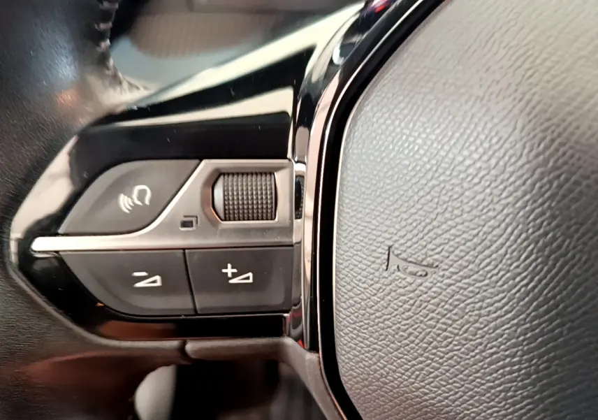 Gros plan sur les commandes du volant cuir noir de la Peugeot 208 PureTech 100 S&S Allure Business 2020.