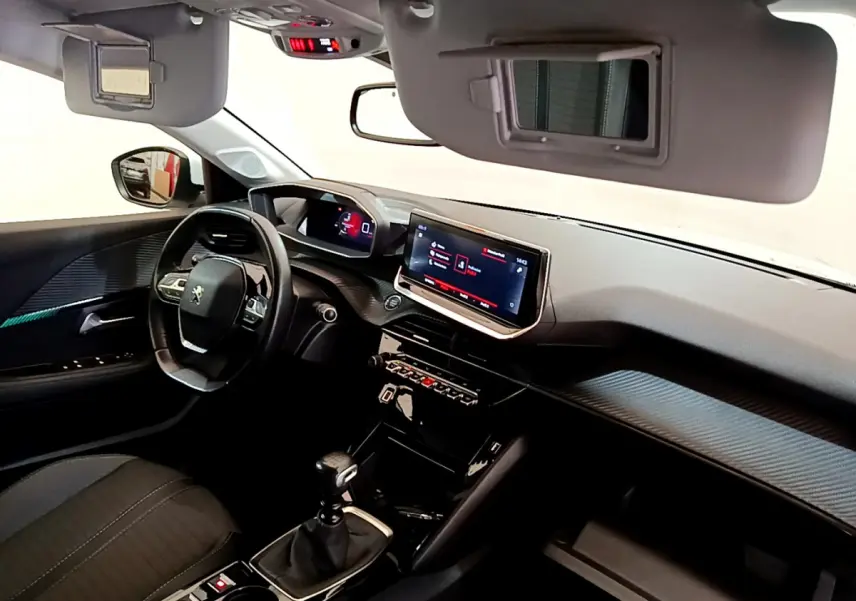 Intérieur de la Peugeot 208 blanc, vue côté conducteur, tableau de bord moderne avec écran tactile et volant cuir.
