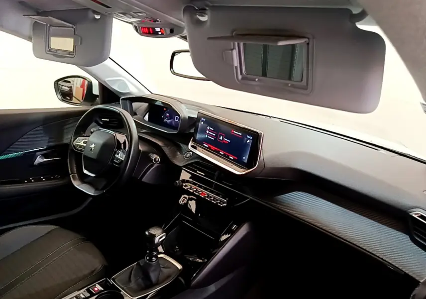 Vue intérieure côté conducteur de la Peugeot 208 blanche 2020, avec tableau de bord numérique et écran tactile central.