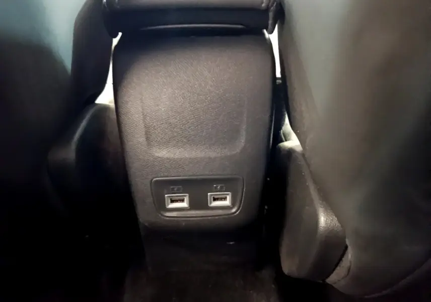 Vue rapprochée des ports USB arrière entre les sièges noirs d'une Peugeot 208 PureTech 100 S&S Allure Business 2020.