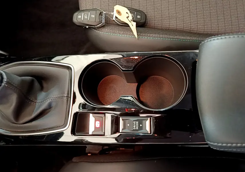 Vue rapprochée de la console centrale noire avec levier de vitesse manuel et porte-gobelets dans une Peugeot 208 blanche 2020.