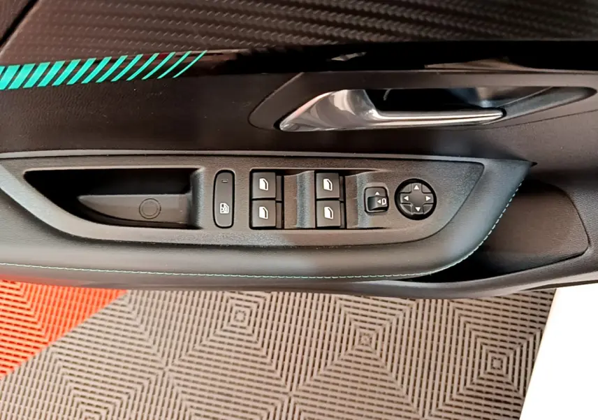 Gros plan sur la commande des vitres et rétroviseurs côté conducteur d'une Peugeot 208 blanche, intérieur noir.