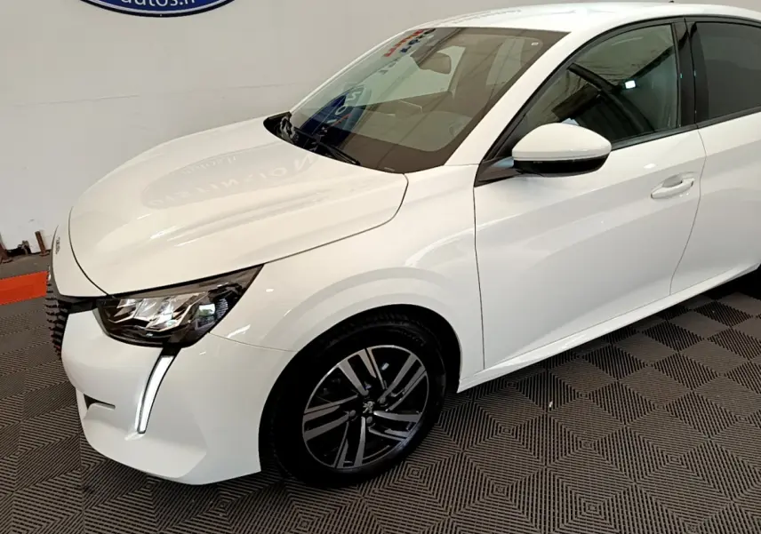 Peugeot 208 blanc vue 3/4 avant droit, avec phares LED et jantes alliage noires distinctives.