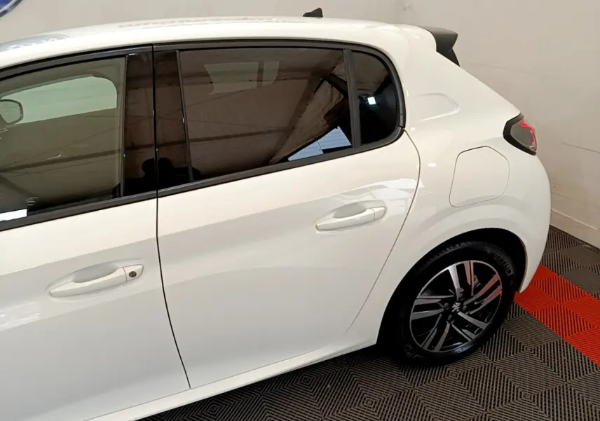 Vue latérale droite du Peugeot 208 blanc 2020, soulignant la porte arrière et la jante alliage moderne.