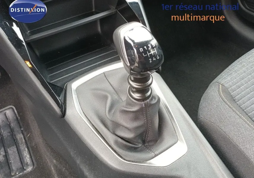 Le levier de vitesses manuel de la Peugeot 208 1.2 100CH S&S STYLE, vue rapprochée de l'intérieur.