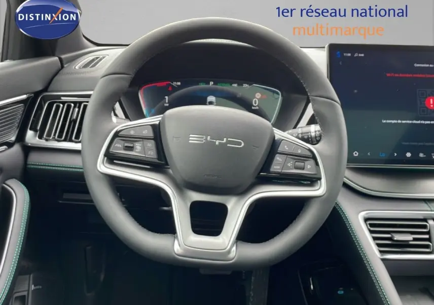 Vue intérieure centrée sur le volant BYD SEAL U gris avec tableau de bord numérique et écran tactile moderne.