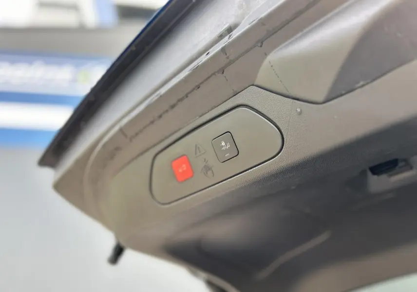 Boutons de commande du hayon électrique sur la face intérieure du coffre d'un Opel Grandland Bleu Vertigo.