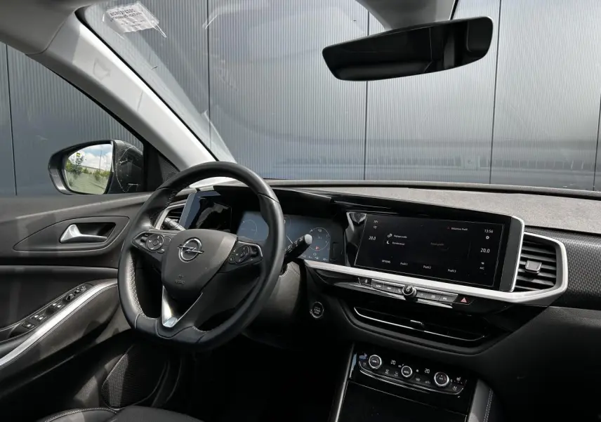 Intérieur de l'Opel Grandland 2022 vu côté conducteur, avec tableau de bord noir et écran tactile large.