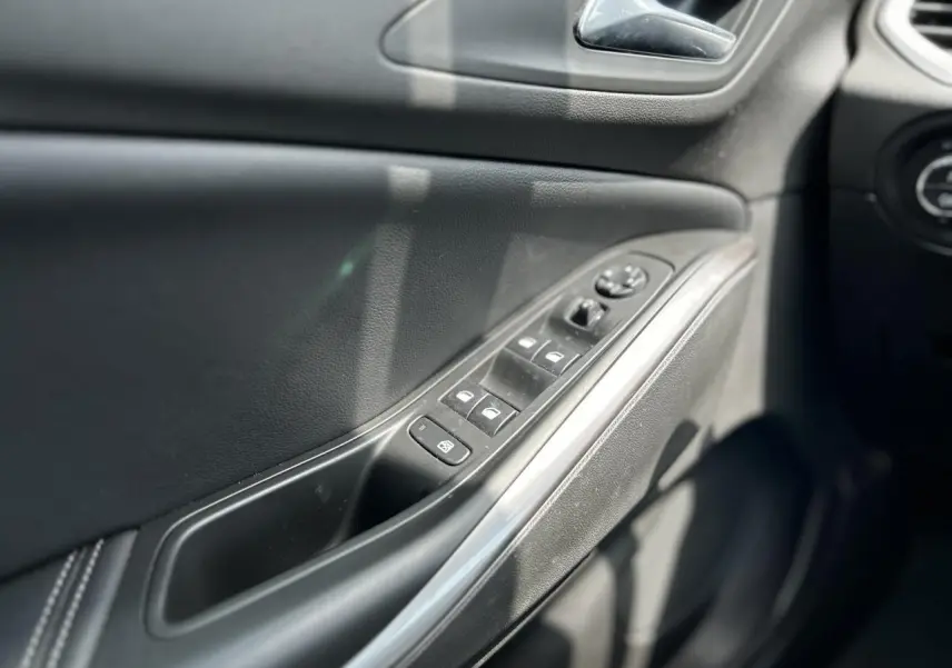 Détail de la porte côté conducteur de l'Opel Grandland 1.6 Hybrid 225 Ultimate avec commandes de vitres et rétroviseurs électriques.