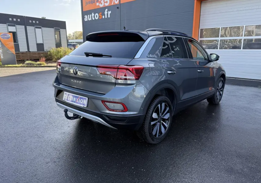 Vue 3/4 arrière droite du Volkswagen T-Roc gris Indium métallisé avec attelage amovible et jantes noires.
